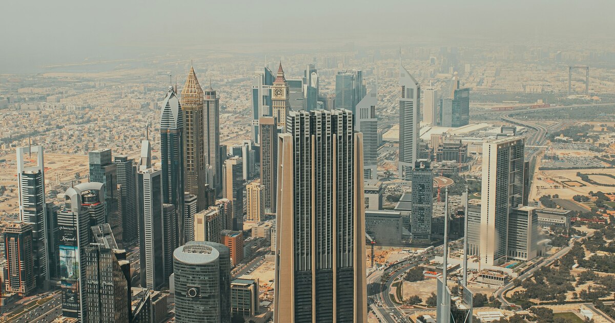 Business documents and laptop on desk showing Dubai DED company registration portal