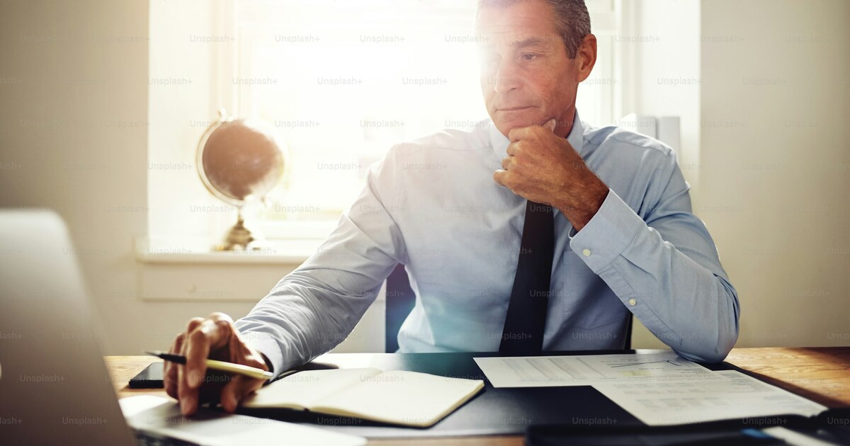 Entrepreneur reviewing business license documents on a desk with laptop showing Dubai DED portal